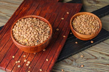 Raw lentils in bowls on table