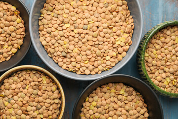 Raw lentils in bowls on table