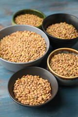 Raw lentils in bowls on table