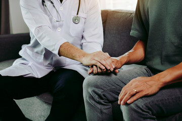 Doctor is holding the hand of the patient by giving him confidence in the doctor.