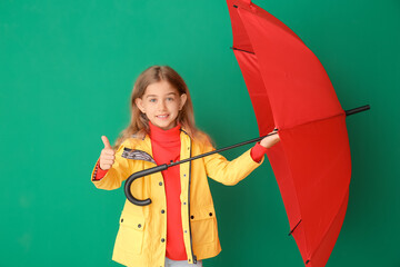 Cute little girl in raincoat and with umbrella on color background