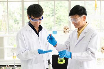 Science, Chemistry, Technology, Biology and Laboratory concept - Portrait of Asian senior and junior scientist is testing an experiment result in petri dish in their laboratory.