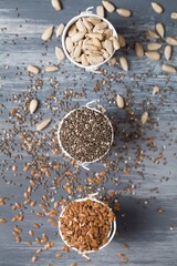 sunflower seeds, flax seeds and chia on blue wooden background