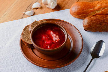 Traditional Ukrainian Russian soup, Borscht. Beetroot soup in bowl on wooden board and rustic wooden background