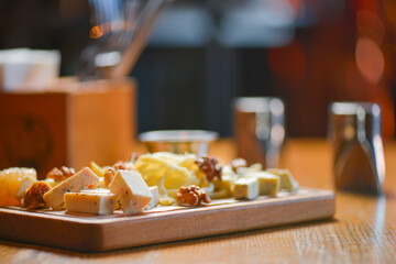 Different sort of farm made cheese served on a wooden board. Cheese platter with different kinds of cheese.