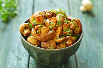 Baked balsamico mushrooms in a rustic green bowl, sprinkled with parsley