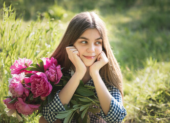 Beautiful girl with a bouquet of peonies