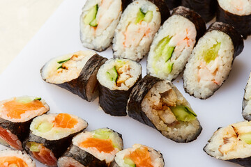 Various kinds of sushi roll set served on cutting board. Japanese food
