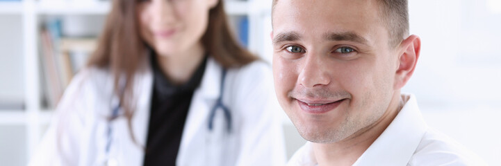 Satisfied happy handsome smiling male patient with doctor at her office. High level and quality medical service, therapeutist consultation, work and career, physical, healthy lifestyle concept