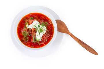 Red beetroot borscht in bowl with wooden spoon, top view
