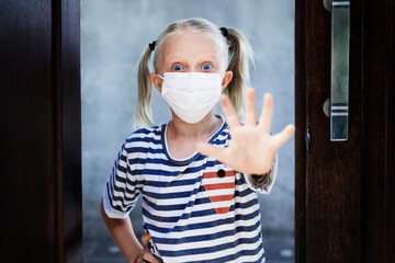 Little child showing hand gesture Stop virus. Kid wearing medical face masks go out for outside walk after staying at home due banned street activity. Ending coronavirus Covid-19 disease quarantine.