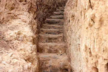 Close up of saircase, carved in clay crag. Steep climb up srairs carved in cliff of loamy soil.