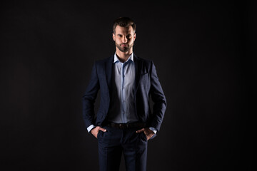 Obraz premium Portrait of his he nice attractive content elegant guy shark agent broker financier specialist recruiter executive manager holding hands in pockets isolated on dark black color background