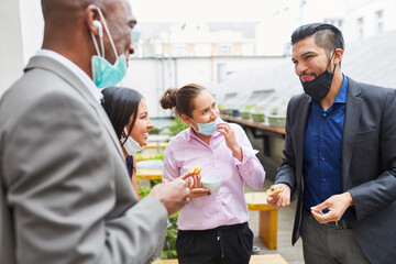 Businesspeople having small talk and eating in a break