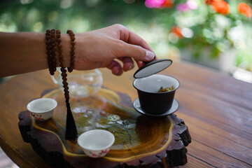 hand with beads conducting a tea ceremony 