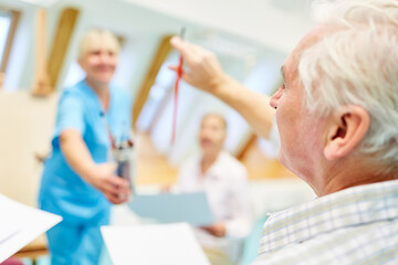 Obraz premium Senioren bekommen Pinsel von Therapeutin