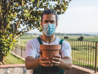 Fototapeta premium a gardener wearing a mask selling a pot 