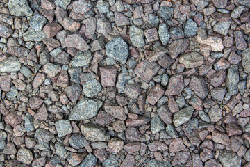 Gray gravel is used in the construction industry. Small road stone background. Granite gravel texture. Pattern of small gravel, rock or stone on the ground for background.