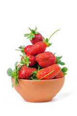 Group of fresh strawberries in the clay bowl, white background