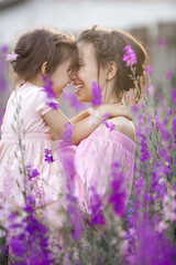 Pretty little girl and her mother with flowers. Family outdoors