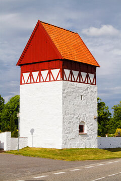 Sankt Bodil Kirke, Bornholm, Denmarm. Old medieval building with half timbering and white chalked base used as a bell tower. The stones in front are tomb stones from the 1600's.