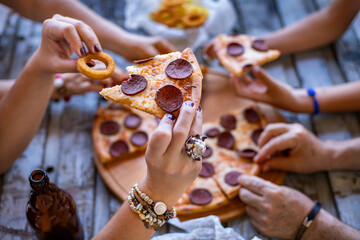 Obraz premium Many hand on the table with pizza slice