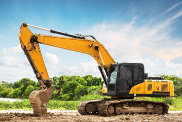 Fototapeta na wymiar Excavator backhoe on the ground at construction site in blue sky background