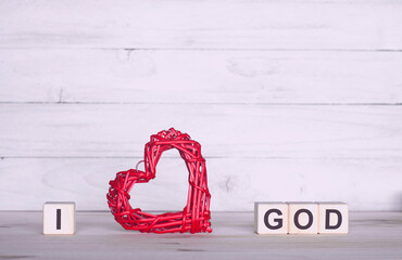 I love God. The inscription on wooden cubes. On a white background. Red heart