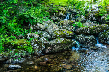 Waterfall in two streams with big stones near the water