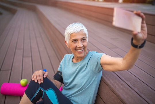 Happy Mature Woman Taking A Selfie At Workout. Concept About People, Gym, Sport. Selfie Time. Cheerful Positive Happy Adult Senior Female Person Smile.