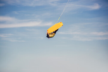 Professional kiter makes the difficult trick on a beautiful background. Kitesurfing Kiteboarding action photos man among waves quickly goes