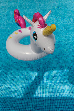Inflatable unicorn floating in swimming pool. Unicorn inflatable pool float.