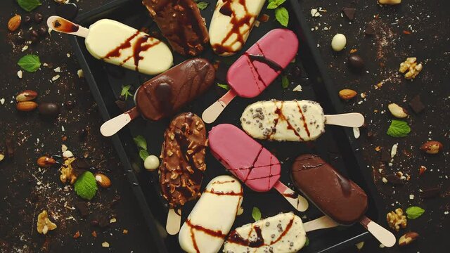 Set of delicious white and milk chocolate and strawberry ice cream on a stick served in metal tray