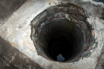 Groundwater well with water in the bottom.