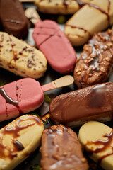 Ice cream on stick coated with various chocolate glazes and toppings. Top view, flat lay