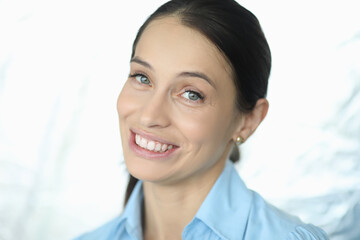 Close up of happy pretty adult woman in blue shirt smiling fun at the camera on white background. Work concept
