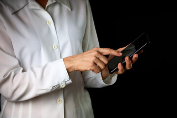Close-up of a businesswoman's hands connecting to her cell phone