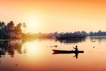 An unidentified woman sails her canoe in tranquil backwaters in