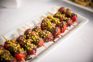 Erdbeeren am Holzspieß mit Schokolade und Pistazien