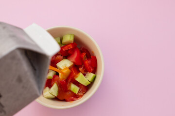 cold tomato soup gaspacho with bread in white bowl on ceramic background