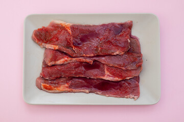 raw meat with spices on grey dish