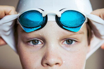 Portrait of a swimmer boy in a hat and glasses