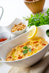 hummus paste with lemon and chilli on white background