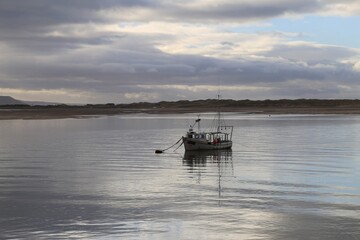 An early morning scene of a fishing boat in the Dyfi Estuary, Gwynedd, Wales, UK