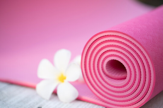 pink yoga mat and a flower outdoor, healthy and sport concept