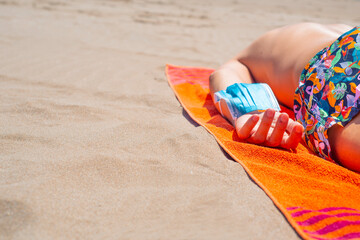 man wearing surgical mask in his arm on the beach