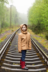 Cute red hair girl walking on railway alone, she is sad. The only one way to travel in coronavirus...