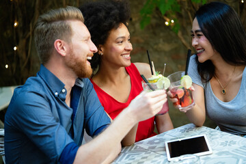 Multiracial group of friends having fun and talking in restaurant