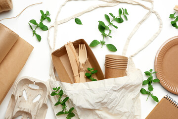 textile bag and disposable tableware from brown craft paper, green mint leaves