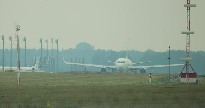 
The airport is a small plane crossing the road to a large airliner. Two planes are moving in the frame.